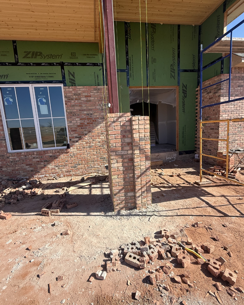 Brick masonry progress at the Grace on 5 entry with reclaimed-look brick supplied by Caprock Brick