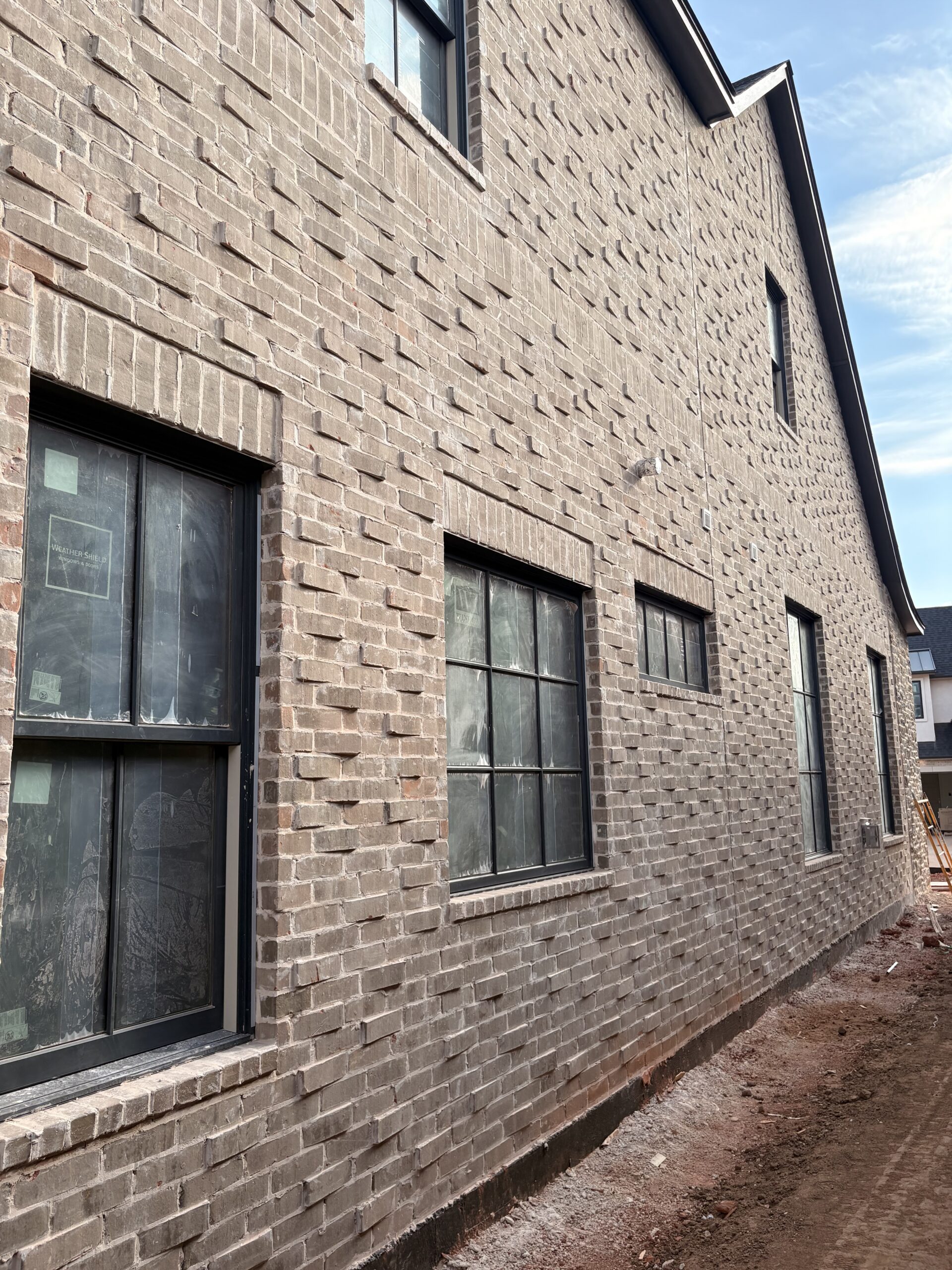 Greystone brick exterior with dark windows and projecting brick details